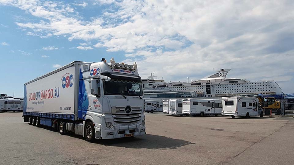 Truck levert aan schip in de haven